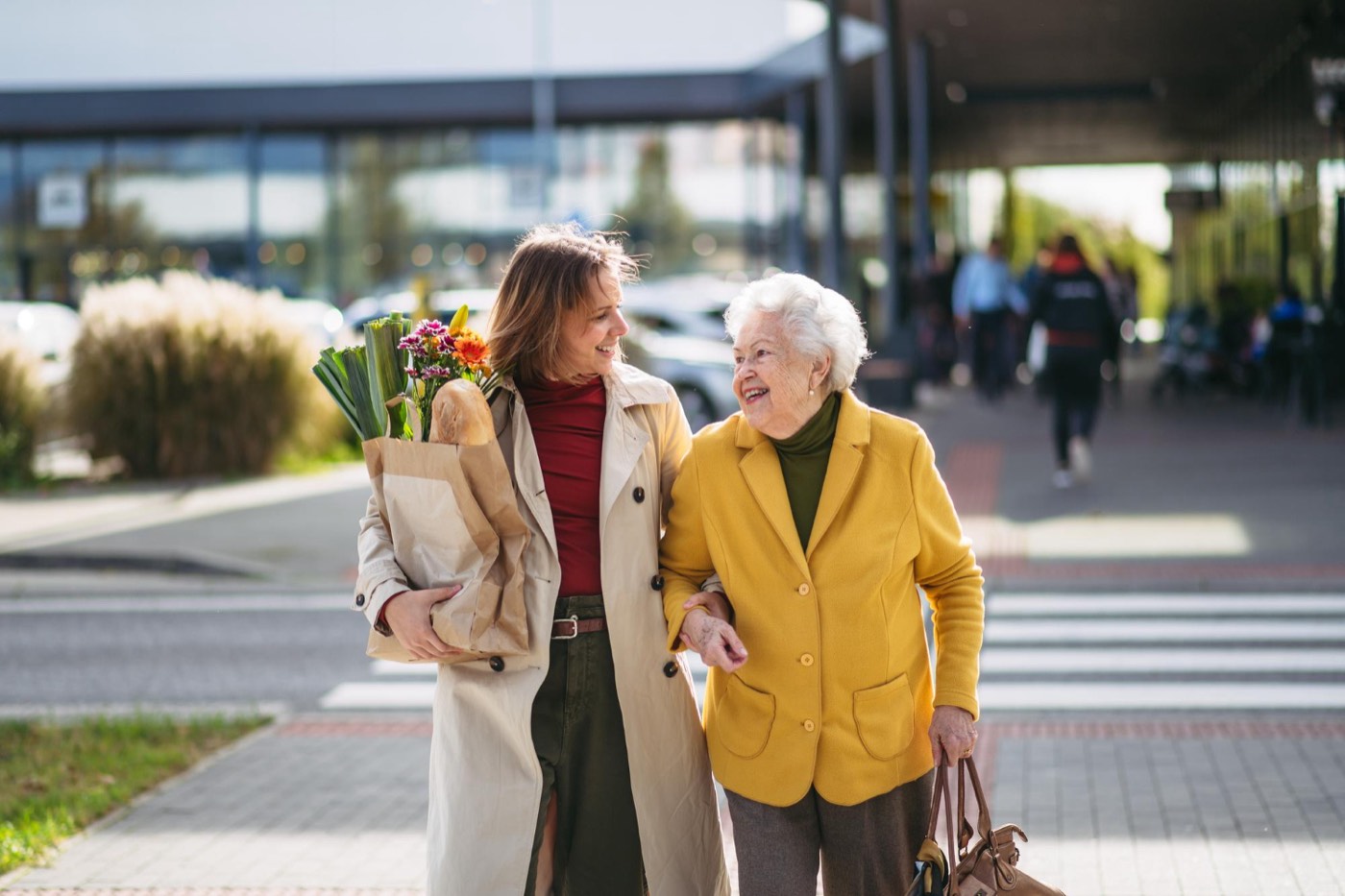 Betreuungskraft begleitet eine Seniorin beim Einkauf
